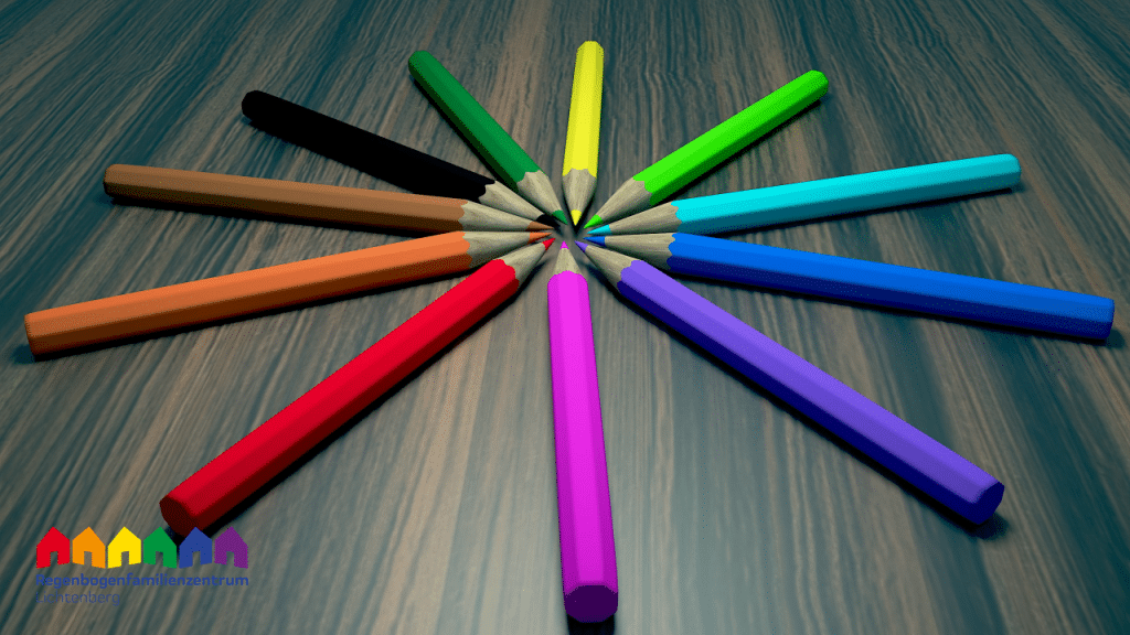 Bild von Stiften in Regenbogenfarben zum Kreis auf Holzplatte